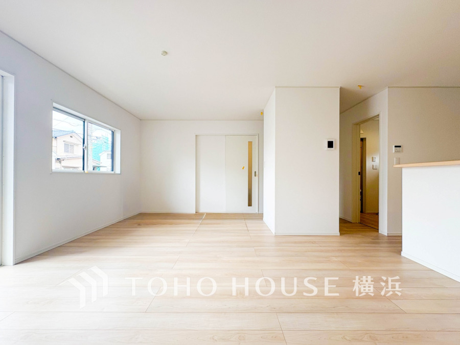 明るい自然光が差し込む、シンプルで広々としたリビング空間。家族の団らんに最適です。