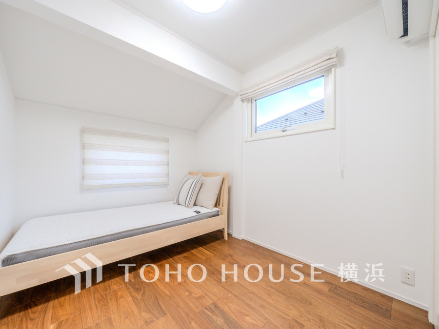 木目が美しいフローリングと白壁が調和する、清潔感あふれる洋室です。