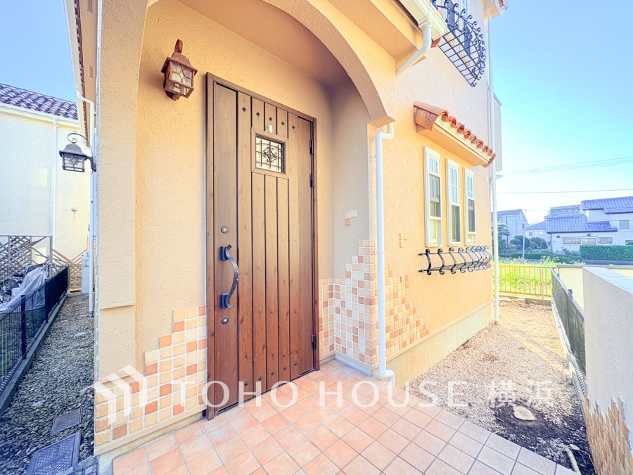 温かみのあるタイルと木製ドアが調和した、明るく開放的な玄関アプローチ。住まいの顔として魅力的です。