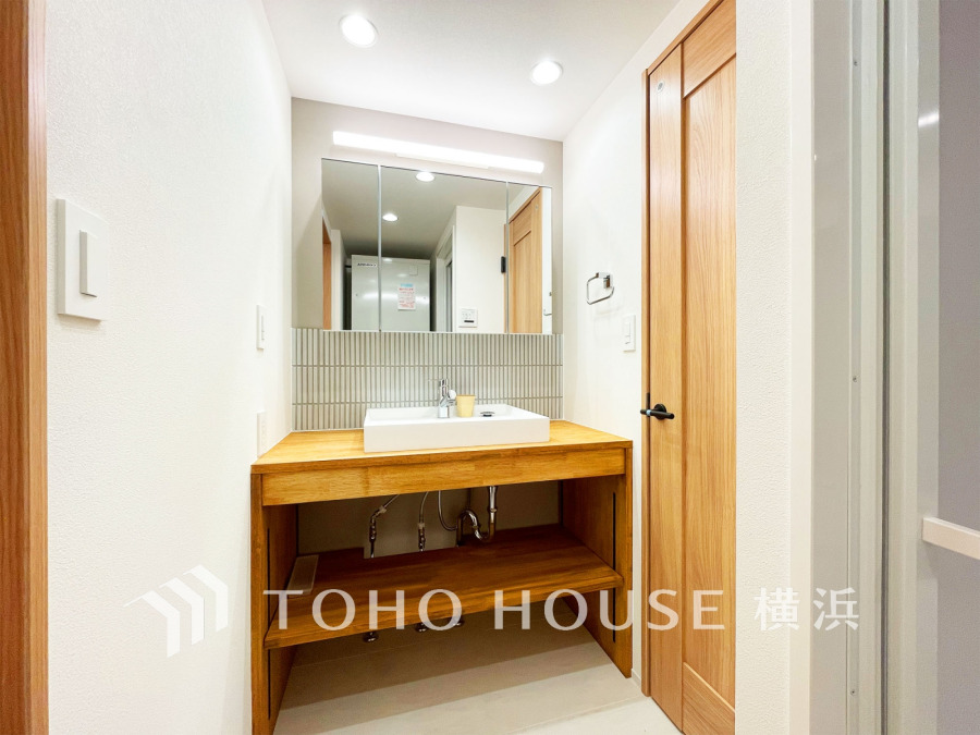 新規交換された洗面化粧台で、清潔感のあるスタイリッシュな洗面空間。