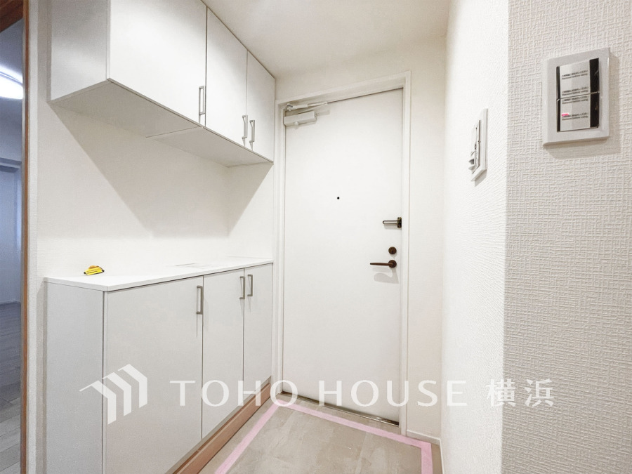 清潔感あふれる白を基調とした玄関収納付きのシンプルな玄関スペース。