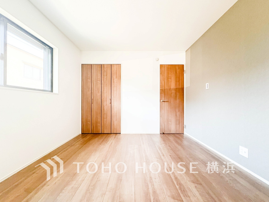 木目調の扉とフローリングが温かみを演出する、明るく開放的な洋室です。収納も充実しています。