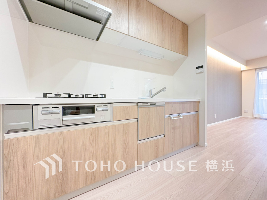 ナチュラルな木目調の収納が美しい、使いやすさにこだわったシステムキッチン。明るく開放的な空間です。