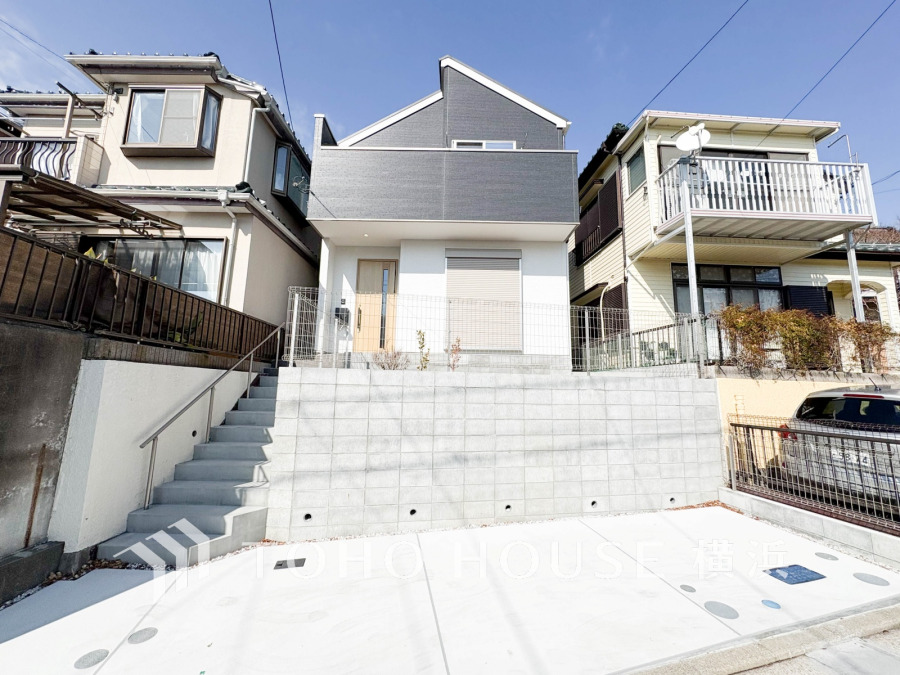 高台に立つモダンデザインの新築一戸建て。駐車スペース完備で、ゆとりある暮らしを実現します。