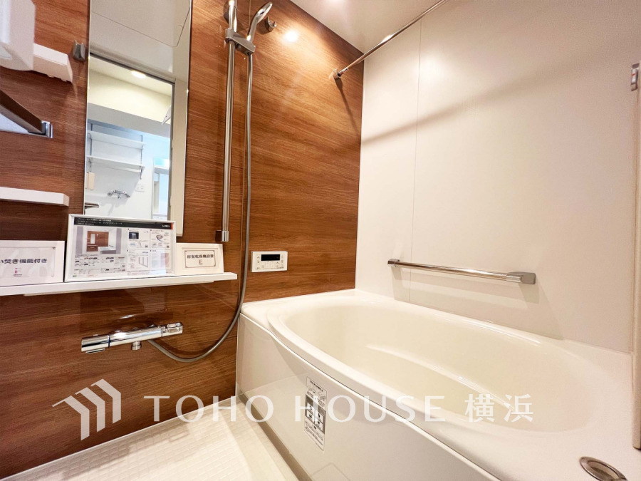 木目調の壁が温かみを演出する、清潔感あふれるバスルーム。浴室乾燥機も完備で快適に過ごせます。