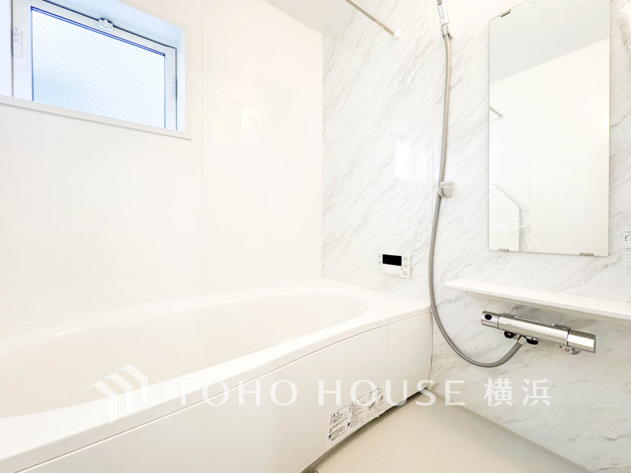 白を基調とした浴室は、ゆったりとしたバスタブと使いやすいシャワー設備で快適なバスタイムを提供します。