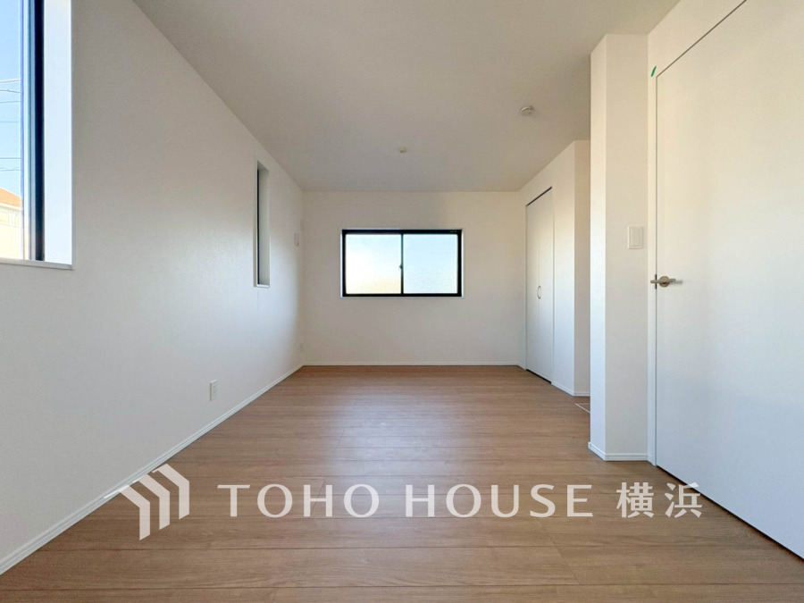 シンプルで明るい空間が広がる洋室。木目調フローリングと白壁が調和し、快適な居住空間を実現しています。