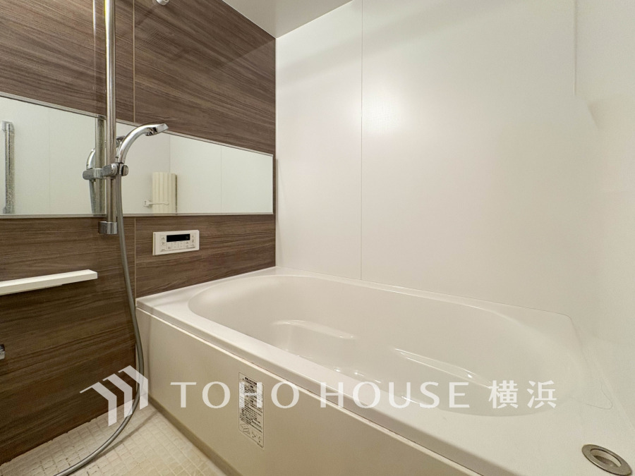 木目調パネルが温かみを演出する、清潔感あふれるゆったりバスルームです。快適な入浴時間を実現します。