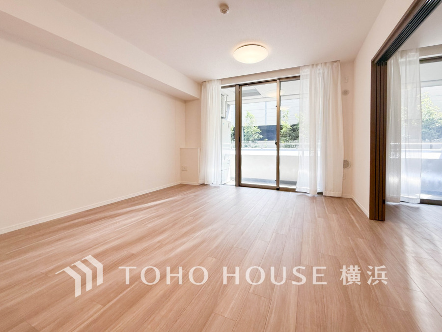 自然光がたっぷり入る明るいリビング。ナチュラルなフローリングが温かみを演出し、快適な住空間を実現します。