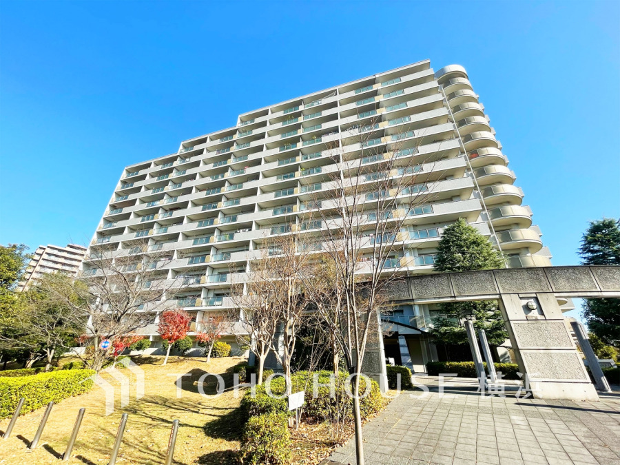 青空に映える高層マンション。緑豊かな植栽と広々とした敷地が、快適な暮らしを演出します。