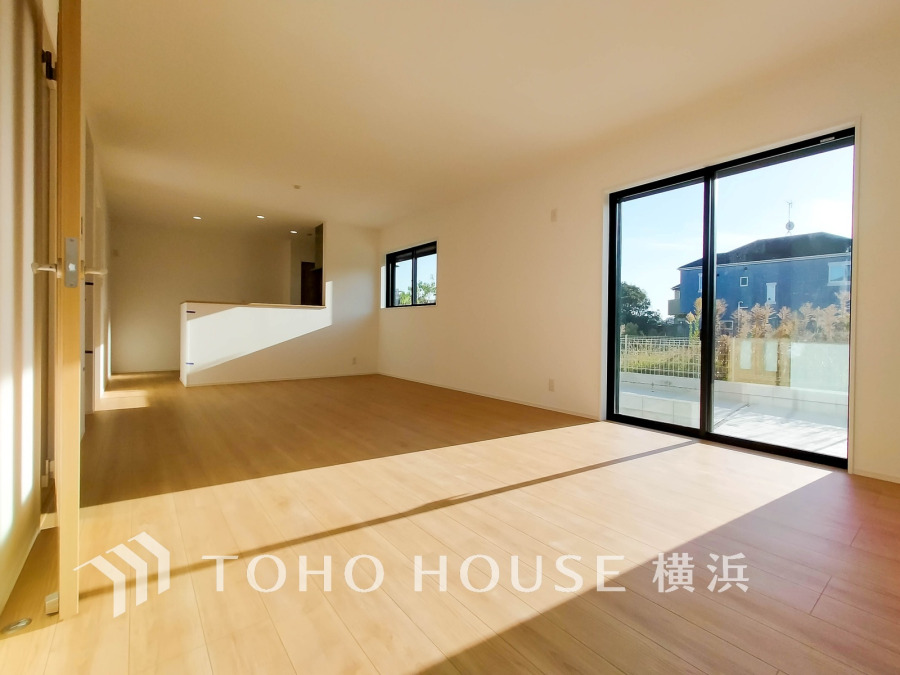 大きな窓から自然光が差し込む、明るく開放的なリビング空間。家族の憩いの場に最適です。