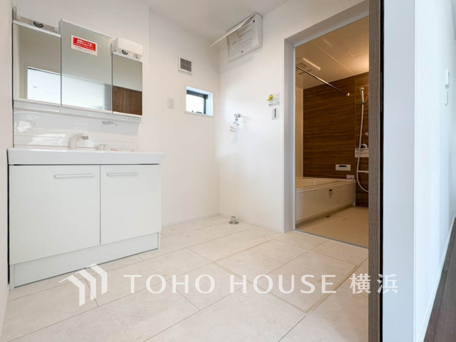 清潔感あふれる洗面室と木目調の落ち着いた浴室が一体となった、快適な水回り空間です。