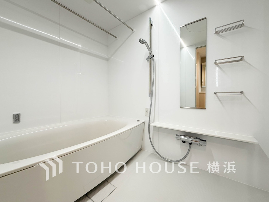 清潔感あふれるホワイト基調の浴室。ゆったり浸かれるバスタブと便利な収納棚付きで快適なバスタイムを実現します。