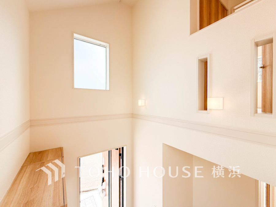 明るく開放的な吹き抜け空間が、家族を優しく迎える温かみのある玄関ホールです。