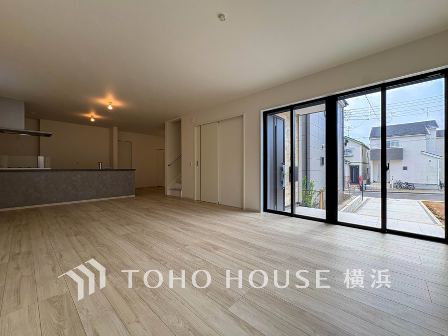 大きな窓から自然光が差し込む、開放感あふれるリビングダイニング。モダンなキッチンと調和した空間です。