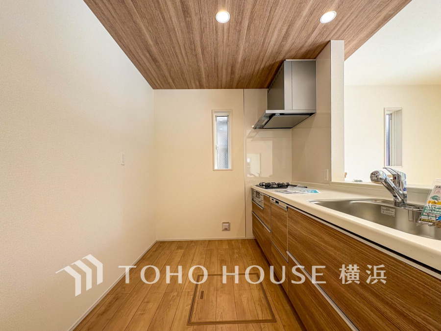 温かみある木目天井と床が調和する、機能的で明るいキッチン空間です。