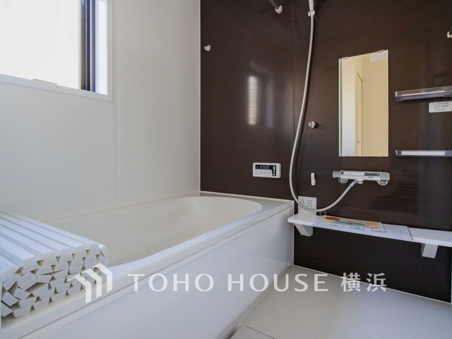 落ち着いたダークブラウンの壁が印象的な、清潔感あふれるモダンなバスルームです。