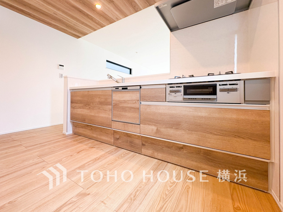木目調の清潔感あるシステムキッチン。広々とした作業スペースで、家族との会話を楽しみながら調理ができます。