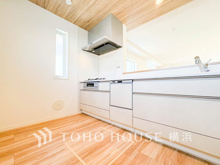 木目調天井が温かみを演出する、明るく開放的なシステムキッチン。収納も充実し使い勝手良好です。