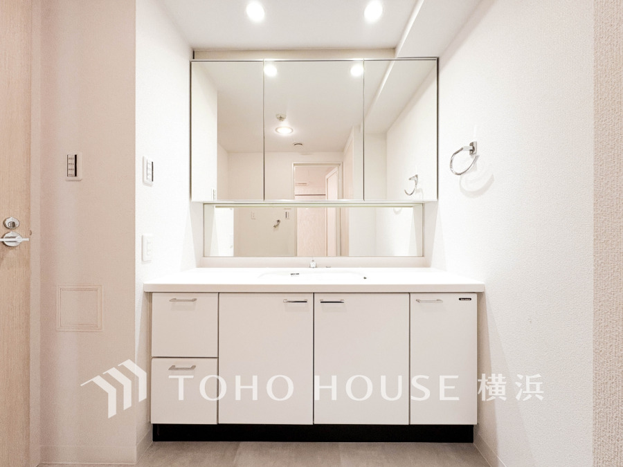 清潔感あふれるホワイト基調の洗面台。大きな鏡とたっぷり収納で毎日の身支度も快適です。