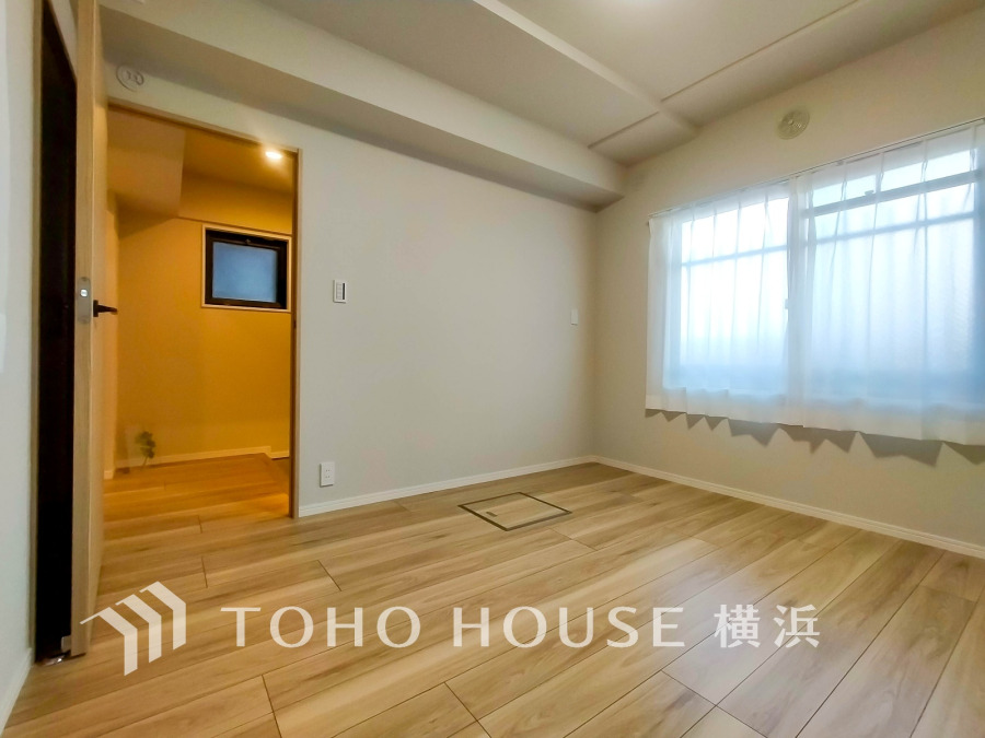 明るい自然光が差し込むシンプルな洋室。フローリングと白壁で清潔感あふれる快適な空間です。