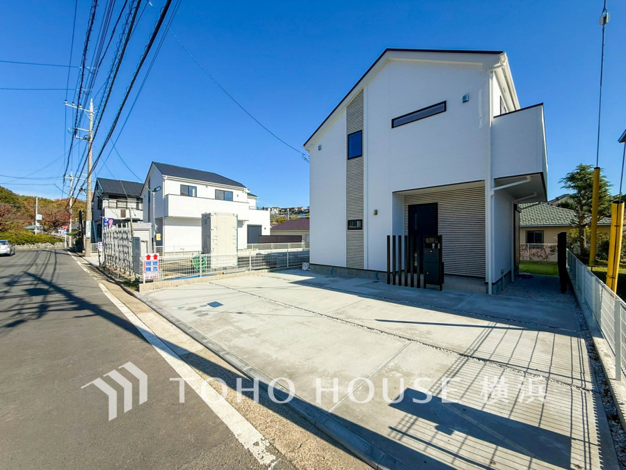 広々とした駐車スペース付きのモダンな白い新築住宅。静かな住宅街で快適な暮らしを実現します。