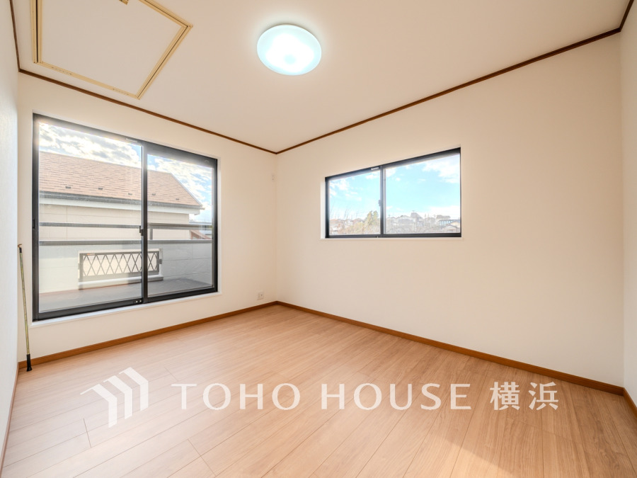 南西向きの大きな窓から明るい光が差し込む、シンプルで清潔感のある洋室です。