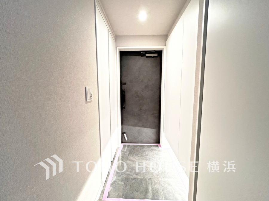 シンプルで清潔感のある玄関ホール。両側に収納があり、スッキリとした印象を演出します。