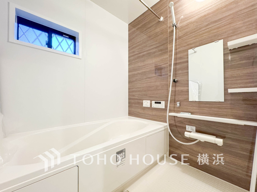 木目調パネルが温かみを演出する、清潔感あふれるバスルーム。ゆったり入浴できる広さが魅力です。