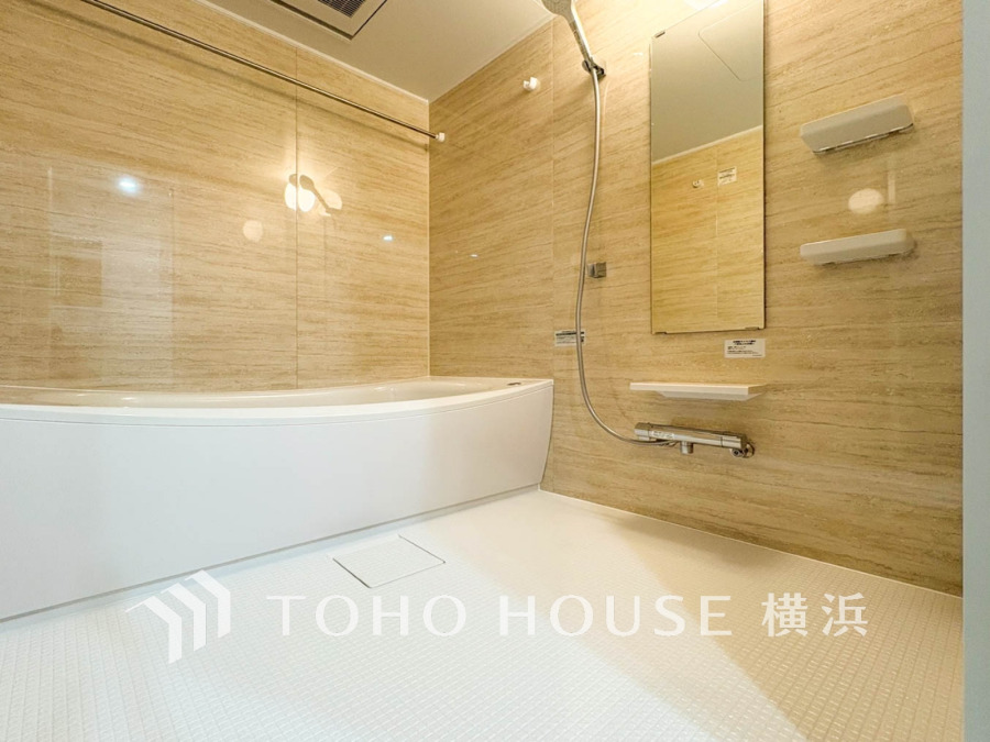 ナチュラルな木目調の壁と清潔感ある白い床が調和した、ゆったりとくつろげるバスルームです。