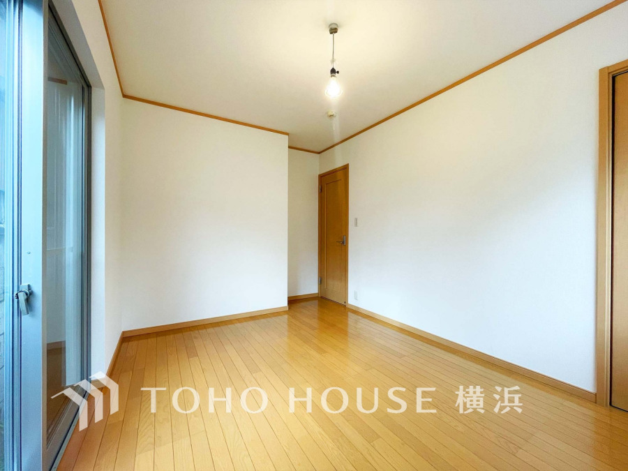 明るい自然光が差し込むシンプルな洋室。木目調のフローリングで温かみのある空間です。