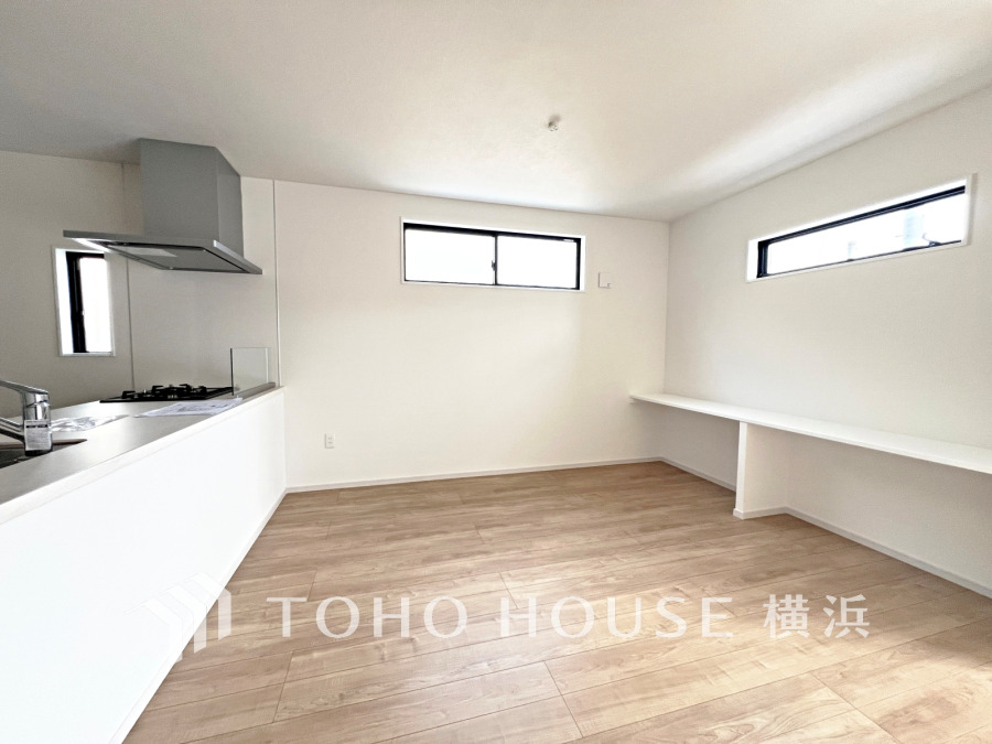 明るい光が差し込むシンプルで広々としたリビング。カウンターキッチンとカウンターが使いやすさを高めます。