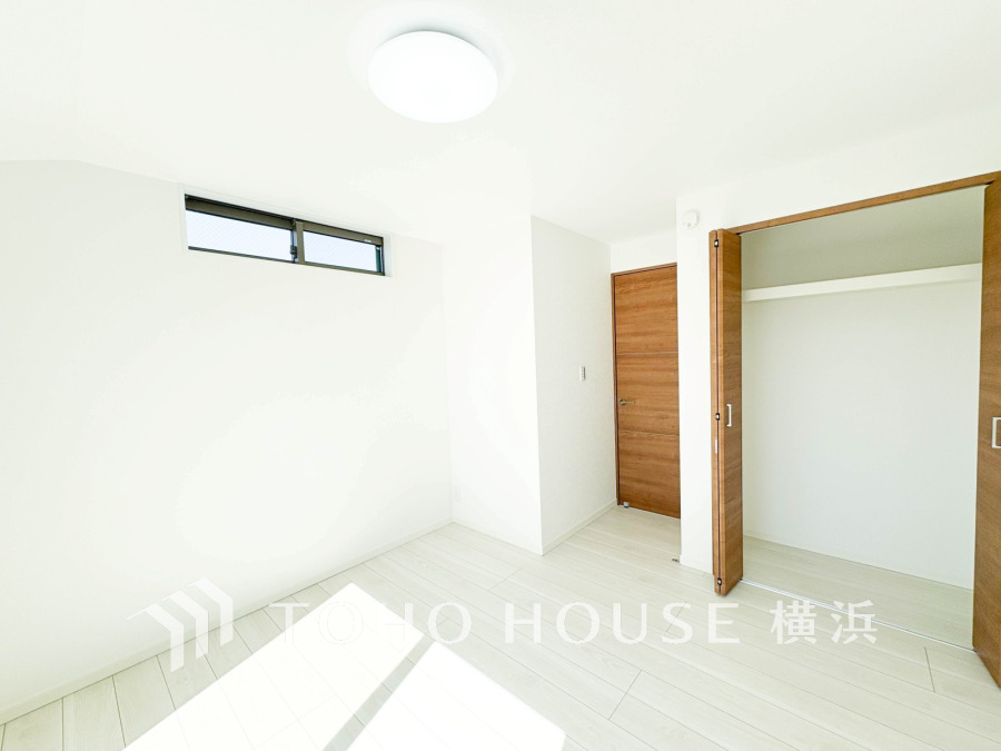 白を基調とした明るい洋室。収納スペースも確保され、シンプルで使いやすい設計です。