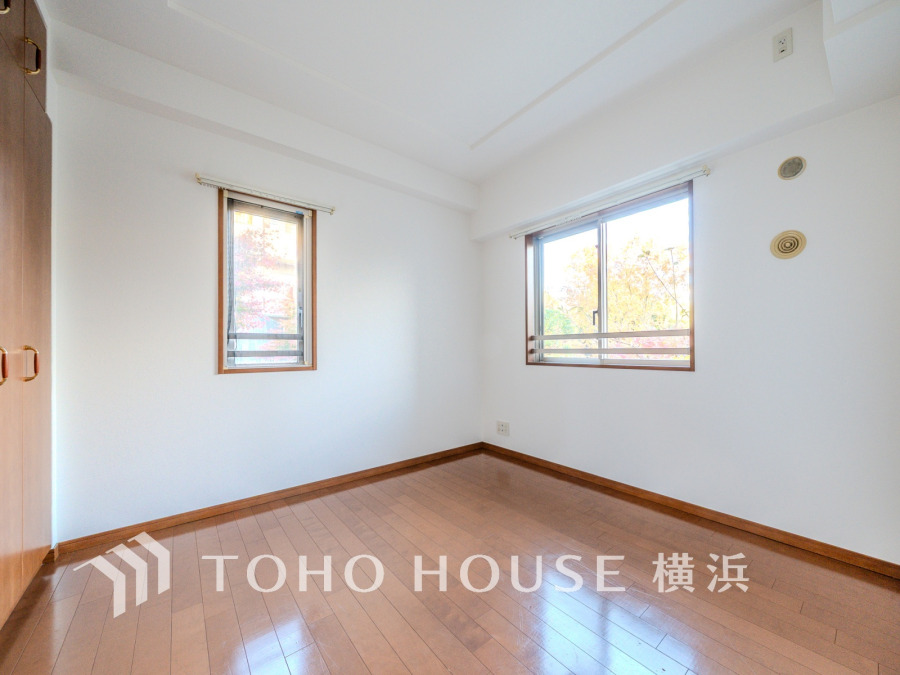 二面採光で明るく風通しの良い洋室。木目調の床と白壁が落ち着いた空間を演出します。収納も充実。