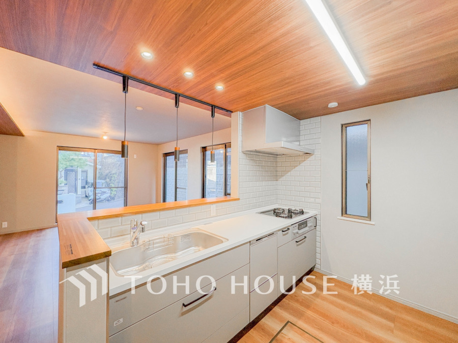 木目天井と白を基調とした清潔感あるキッチン。リビングと繋がる開放的なカウンターで家族の会話も弾みます。