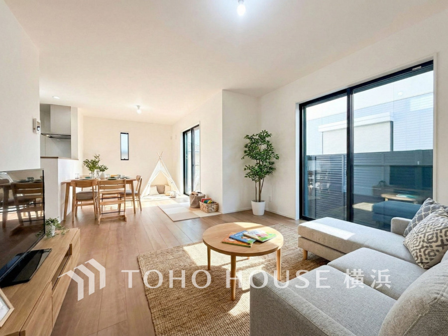 陽光がたっぷり差し込む開放的なリビングダイニング。家族の団らんに最適な温かみのある空間です。（家具はAI加工です）