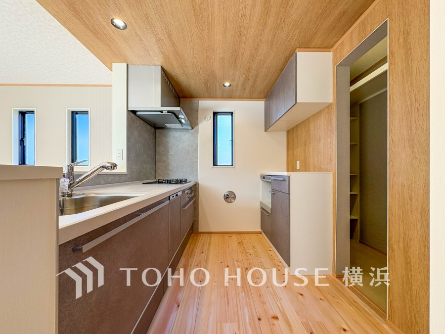 木目調の温かみある空間に、充実の収納と使いやすいシステムキッチンを備えた機能的なキッチンです。