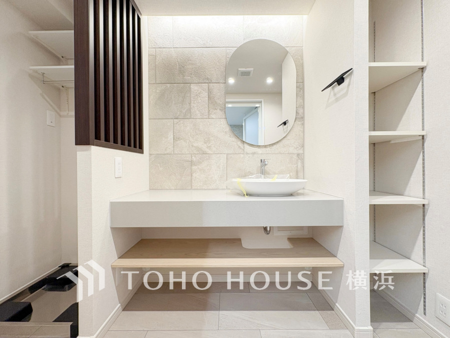 清潔感あふれる洗面スペースは、収納棚付きで機能的かつスタイリッシュなデザインです。