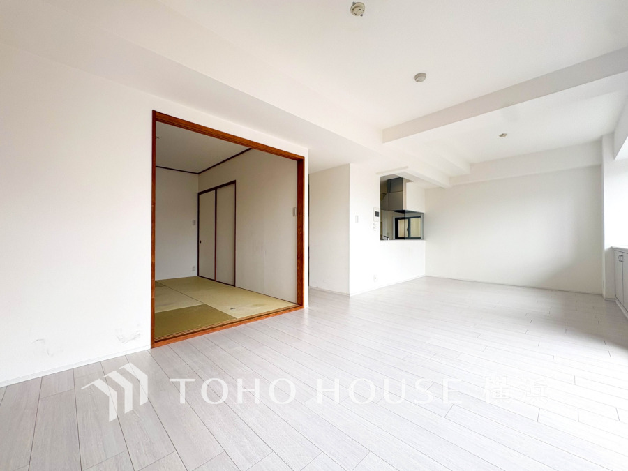 白を基調とした明るいリビングに隣接する畳の和室があり、開放感と落ち着きを両立した空間です。