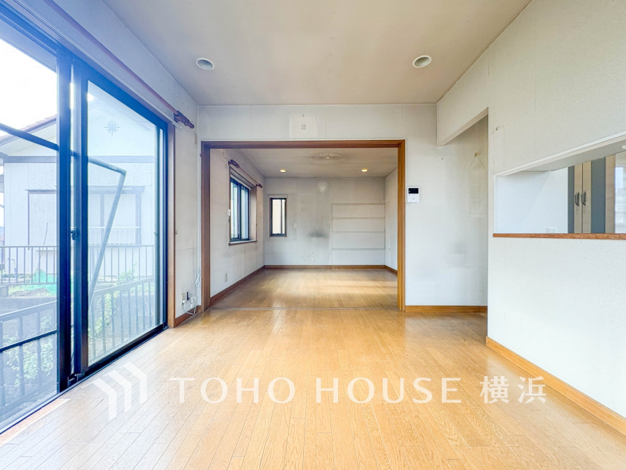 広い窓から自然光が注ぐ明るいリビング。木目調のフローリングと開放感ある間取りが魅力です。