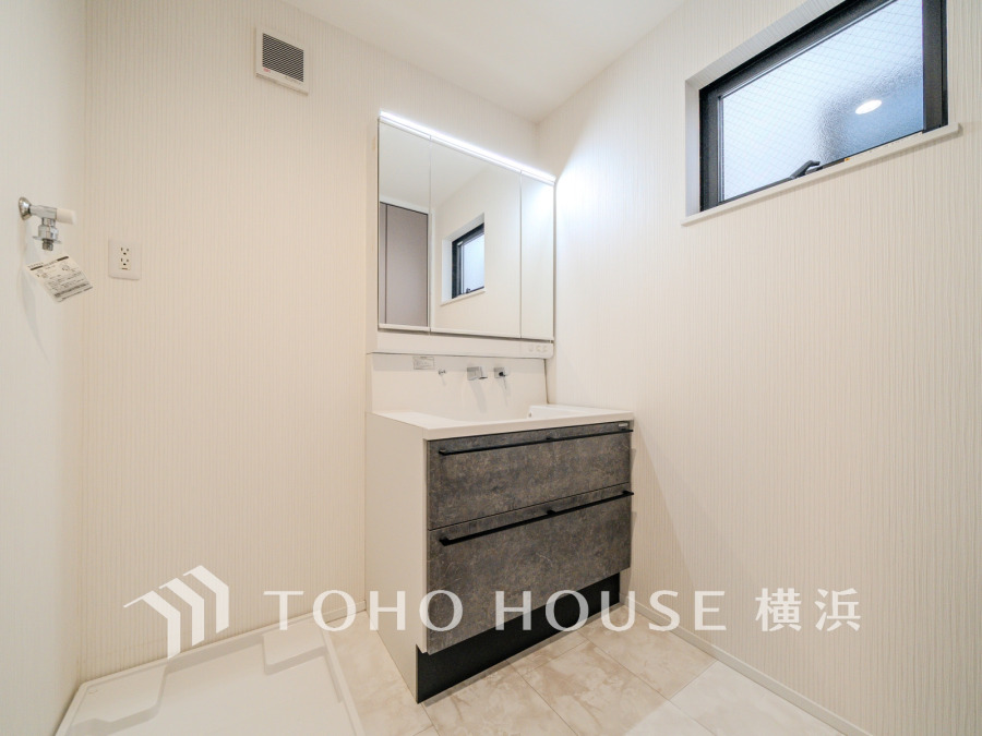 清潔感あふれる洗面スペース。大容量収納と明るい窓で使い勝手と快適さを両立しています。