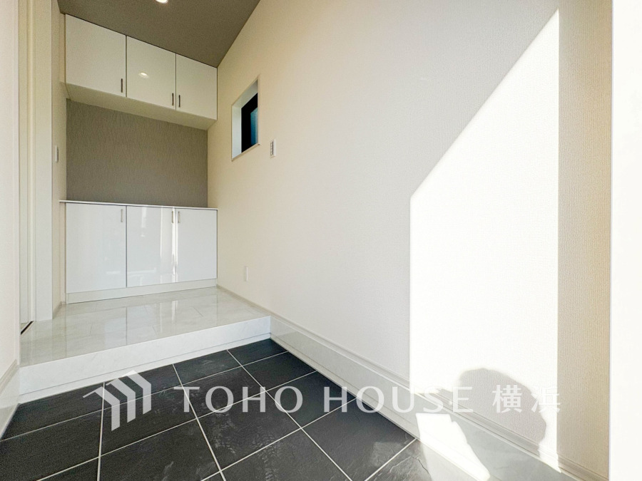 陽光が差し込む清潔感あふれる玄関。収納豊富でスッキリとした空間設計が魅力です。