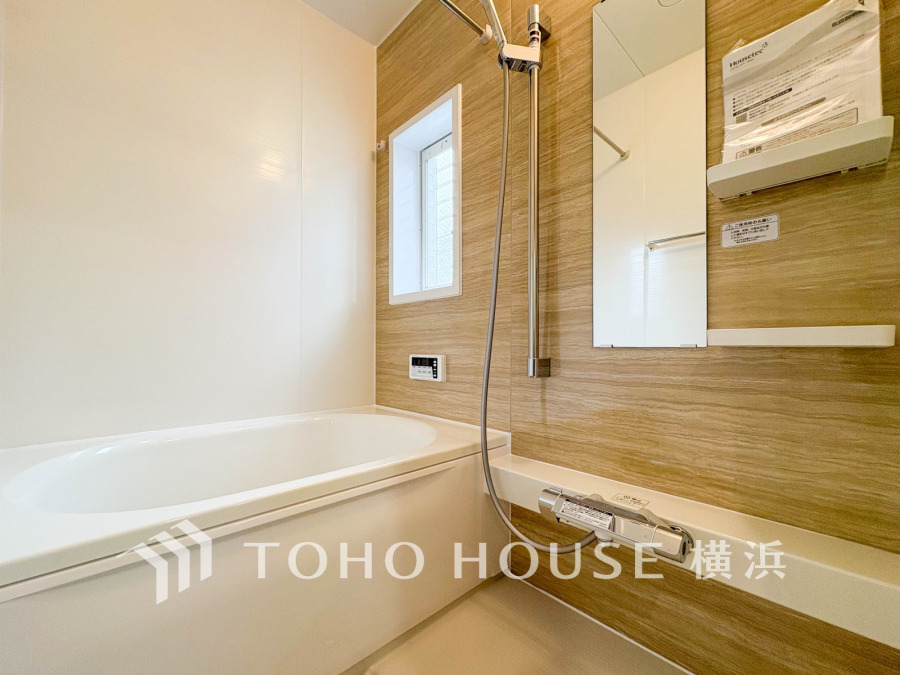 木目調の壁が温かみを演出する、清潔感あふれる快適なバスルームです。窓から自然光もたっぷり入ります。