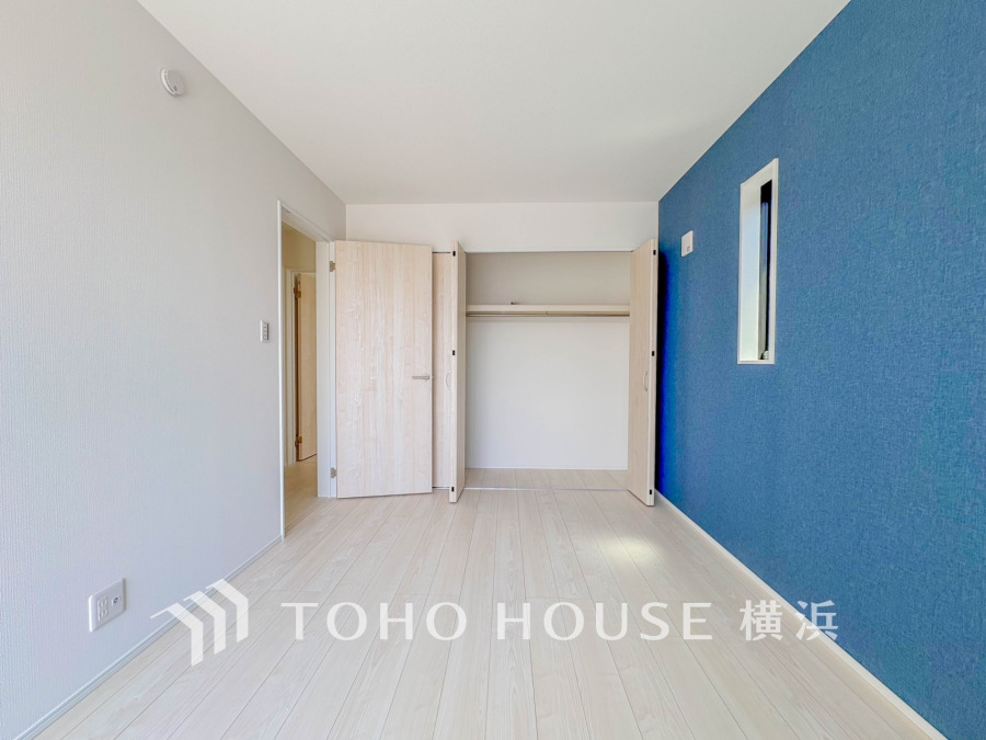 ブルーのアクセントクロスが映える明るい洋室。大容量のクローゼットで収納も充実しています。