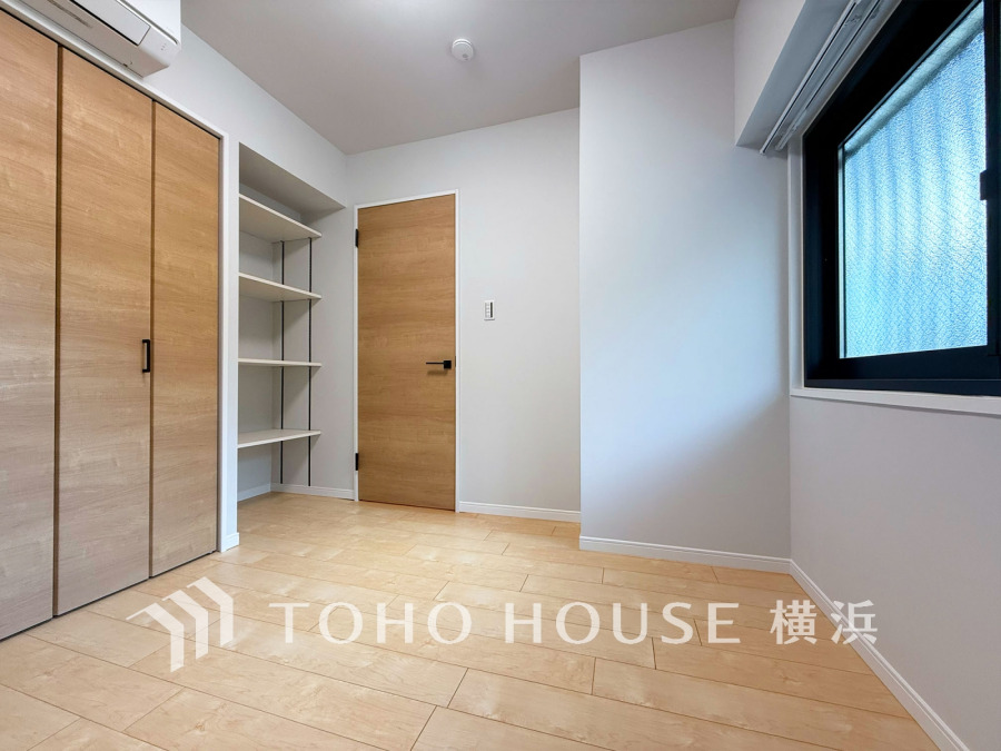 ナチュラルな木目調の収納扉と明るい床が調和した、清潔感あふれるシンプルな居室空間です。