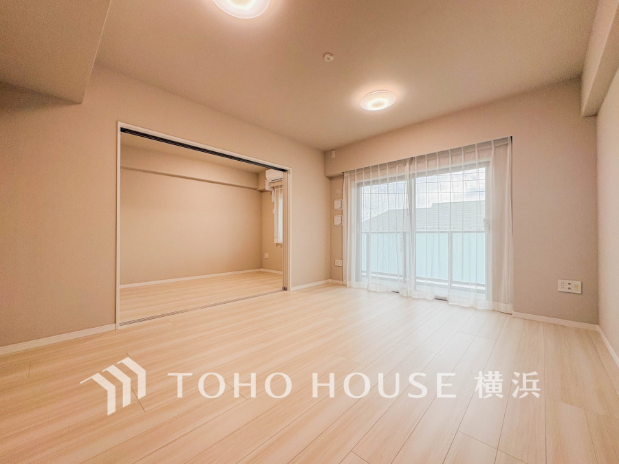 明るい光が差し込む広々としたリビング。スライド扉で隣室とつなげて多用途に使えます。