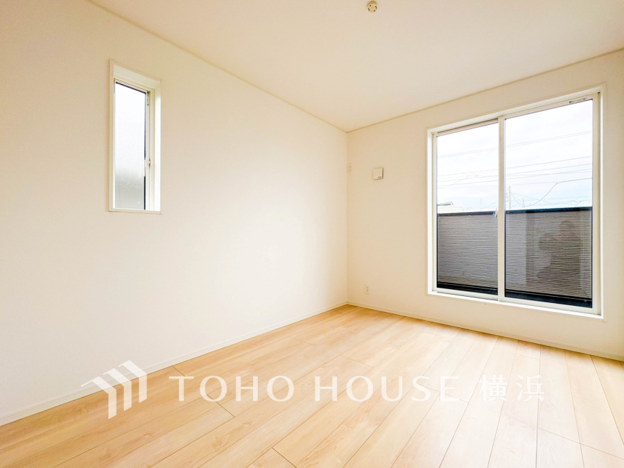 明るい自然光が差し込むシンプルで清潔感のある洋室。広々とした空間で多用途に対応可能です。