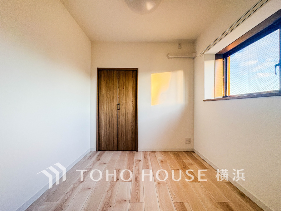 自然光が差し込むシンプルで清潔感のある洋室。木目調のクローゼットと明るいフローリングが温かみを演出します。