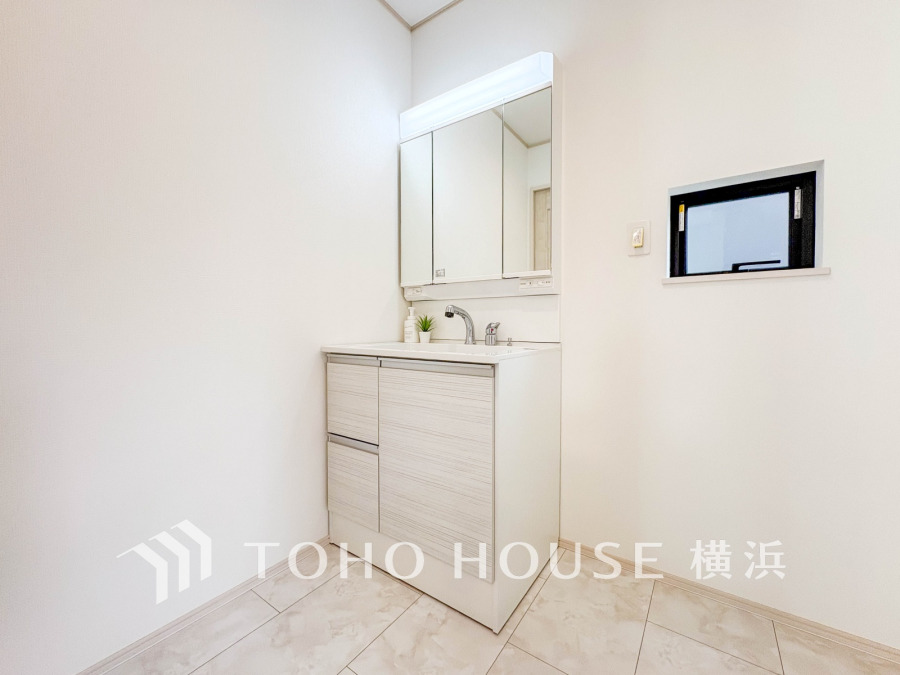 清潔感あふれる白を基調とした洗面スペース。小窓から自然光も入り、明るく快適な空間です。