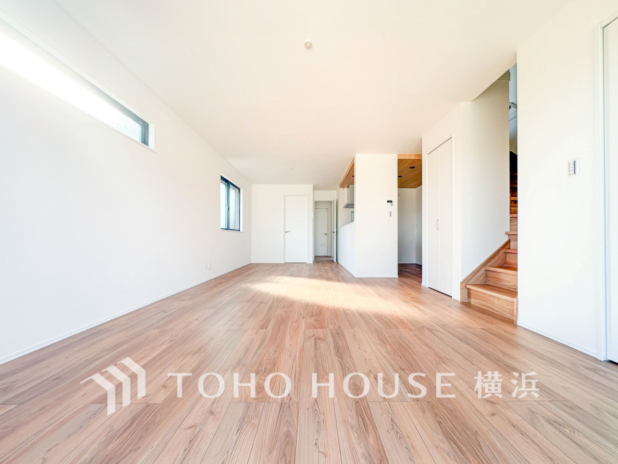 自然光が差し込む明るいリビング。木目調のフローリングが温かみを演出し、開放感あふれる空間です。